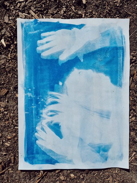 A cyanotype sun print of a child's hands