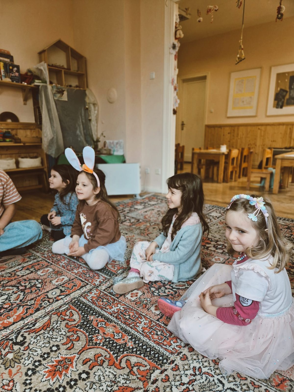 A group of children gathered on the workshop carpet, listening together